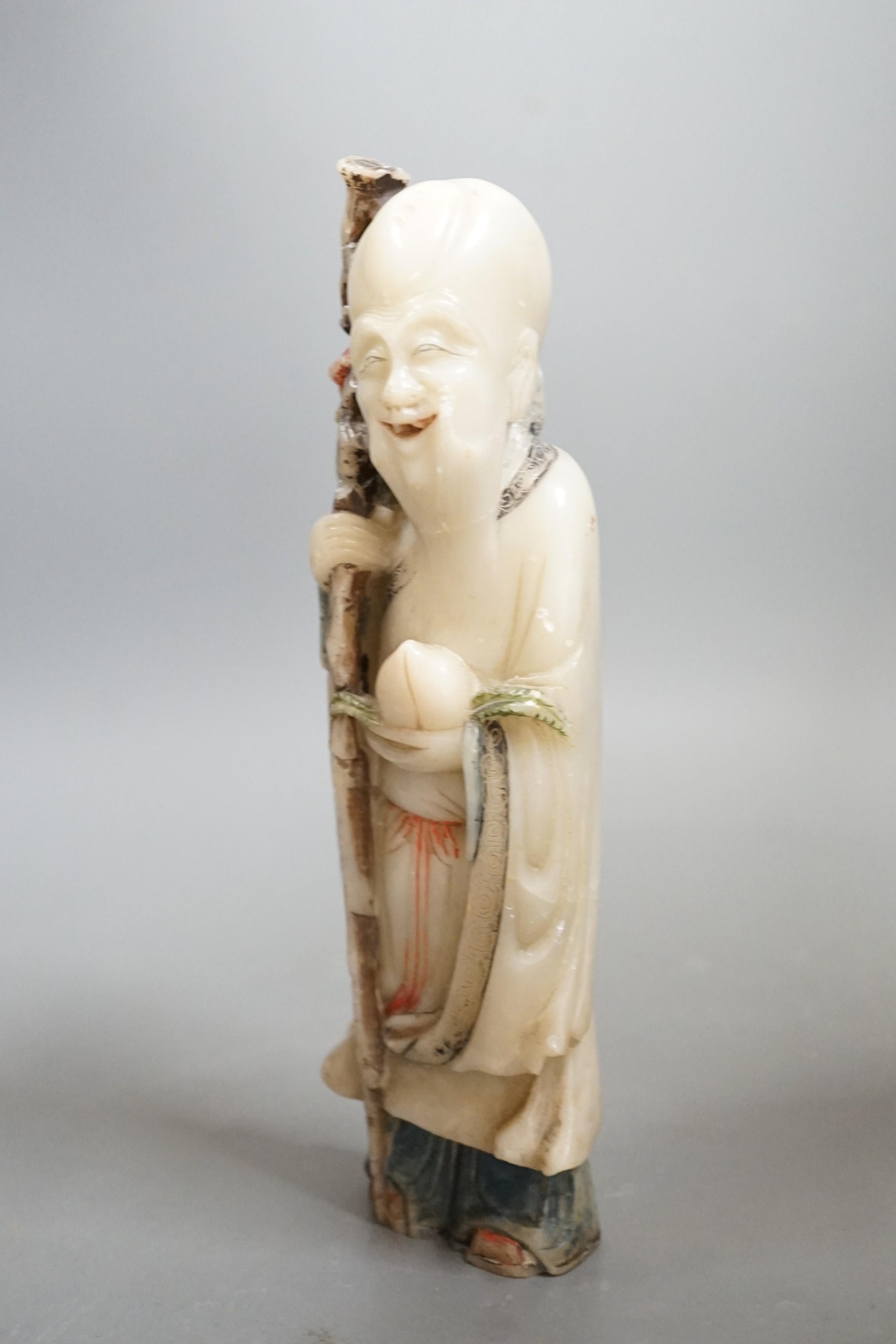 An 18th century Chinese carved soapstone figure of Shao Lou on carved hardwood stand. 24cm high (a.f.)